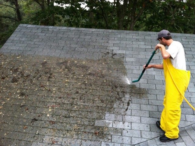 Cleaning a tiled roof from moss with a high pressure device